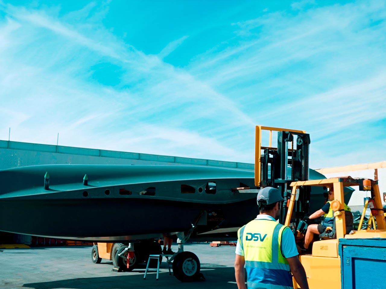 A DSV employee is transporting the items on electric forklifts.